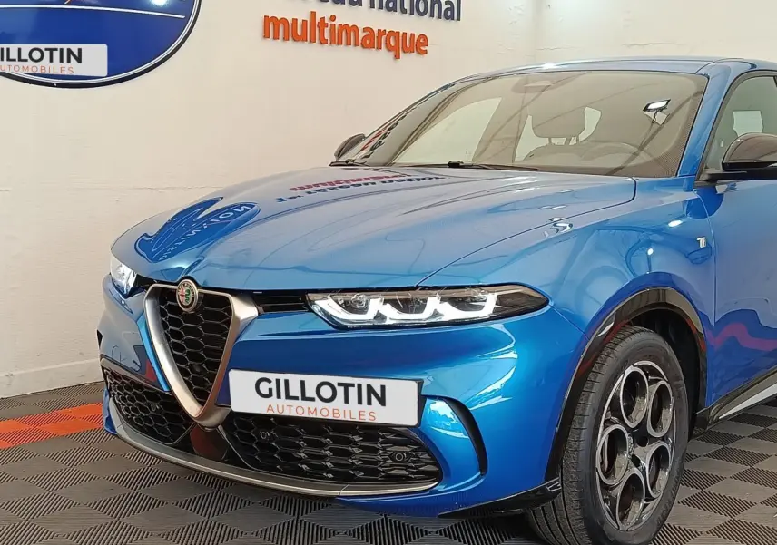 Vue 3/4 avant droite d'une Alfa Romeo Tonale 1.5T Hybrid 160 VGT bleu avec calandre caractéristique et jantes distinctives.