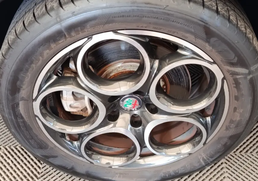 Gros plan sur la jante alu à cinq cercles de l'Alfa Romeo Tonale 1.5T Hybrid 160 VGT avec logo central coloré.