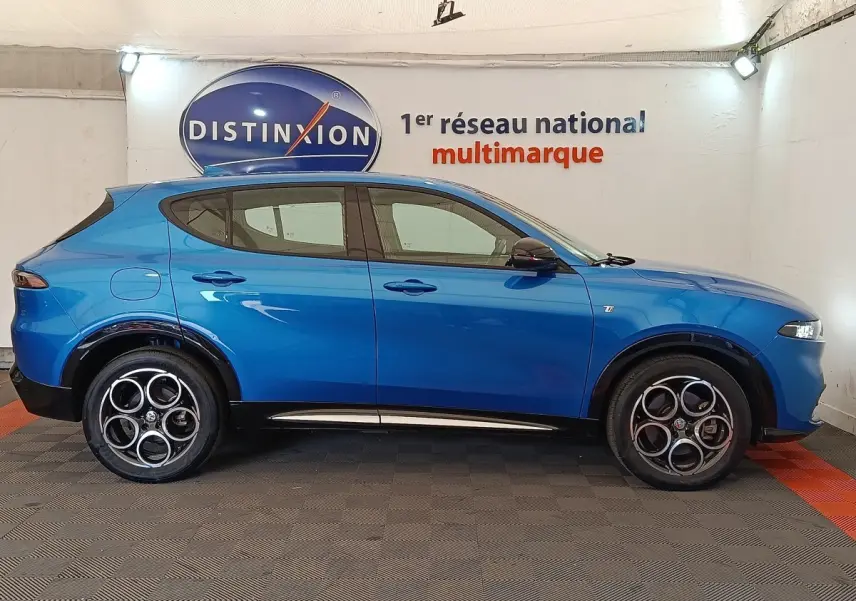 Vue de profil côté gauche de l'Alfa Romeo Tonale 1.5T Hybrid 160 bleu, avec jantes distinctives à cinq cercles.