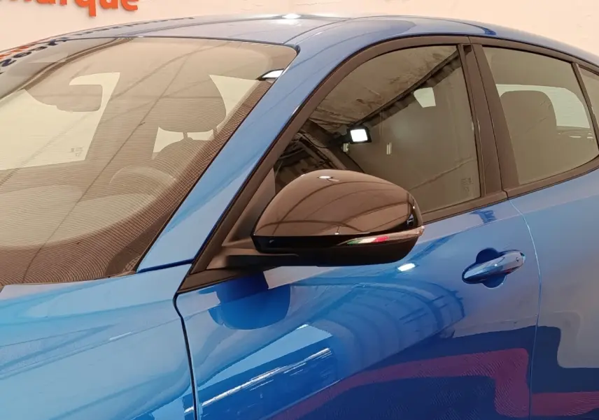 Vue rapprochée côté gauche d’une Alfa Romeo Tonale 1.5T Hybrid 160 VGT bleu avec rétroviseur noir brillant.