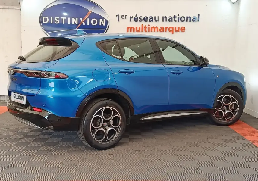 Vue 3/4 arrière droite d'une Alfa Romeo Tonale 1.5T Hybrid 160 VGT bleu avec jantes distinctives en alliage.