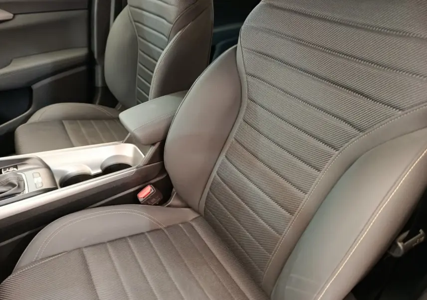 Gros plan sur les sièges avant gris de l'Alfa Romeo Tonale 1.5T Hybrid 160 VGT avec console centrale visible.