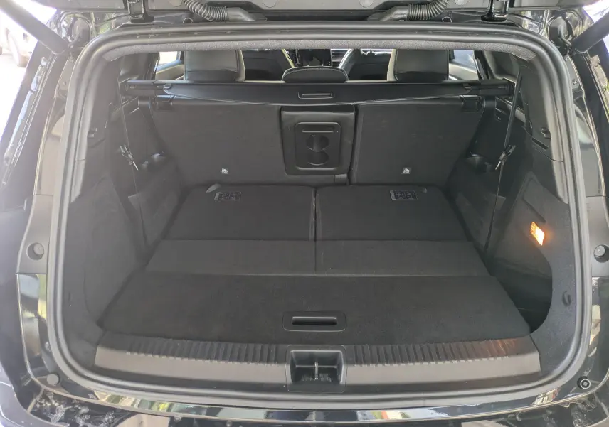Vue arrière du coffre ouvert du Renault Espace VI noir étoile, montrant l'espace de chargement avec sièges rabattus.