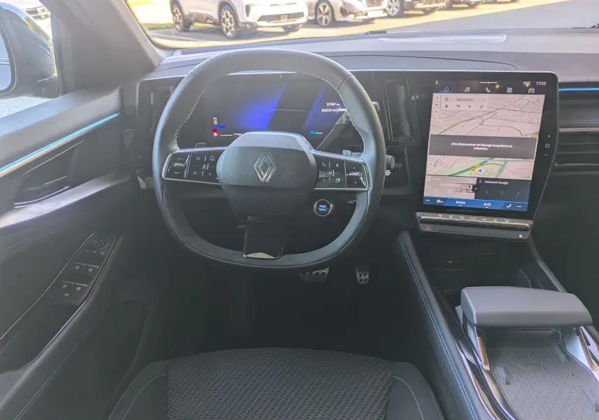 Vue intérieure frontale du tableau de bord du Renault Espace VI E-Tech noir, avec volant multifonction et écran tactile vertical.