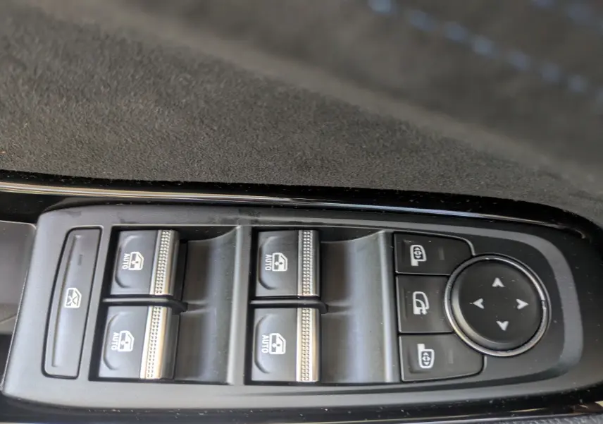 Gros plan sur les commandes de lève-vitres et réglages des rétroviseurs du Renault Espace VI noir étoile.