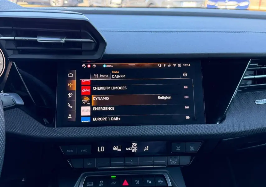 Intérieur de l'Audi A3 Sportback 2025, vue centrale sur l'écran multimédia et commandes de climatisation.