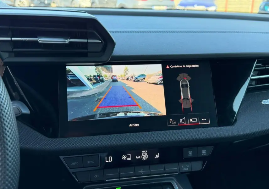 Vue intérieure du tableau de bord de l'Audi A3 Sportback 2025 avec écran de caméra de recul affichant l'arrière en noir Mythic métallisé.