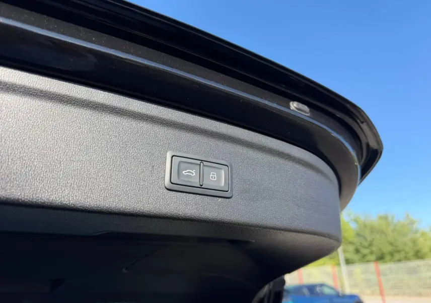 Bouton d'ouverture et de verrouillage du coffre sur la trappe arrière d'une Audi A3 Sportback noir Mythic métallisé.