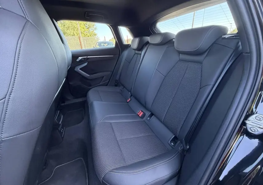 Vue latérale droite sur la banquette arrière noire en tissu et simili de l’Audi A3 Sportback 2025 finition S line.