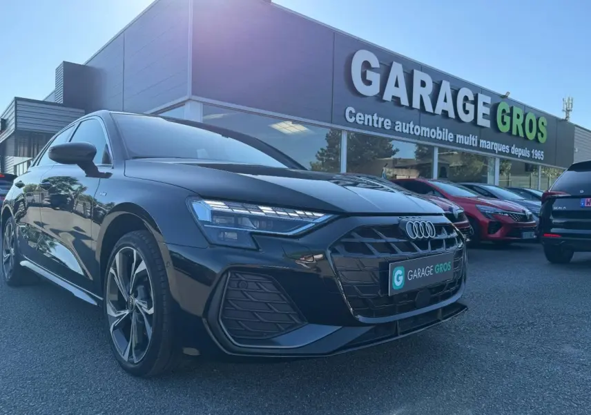 Audi A3 Sportback noir Mythic métallisé vue 3/4 avant gauche, avec jantes alu et calandre S line visible.