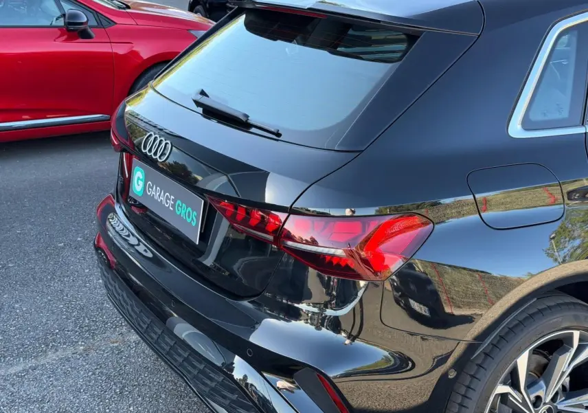 Vue 3/4 arrière droite d'une Audi A3 Sportback 2025 noir Mythic métallisé avec feux arrière LED et jantes alu.