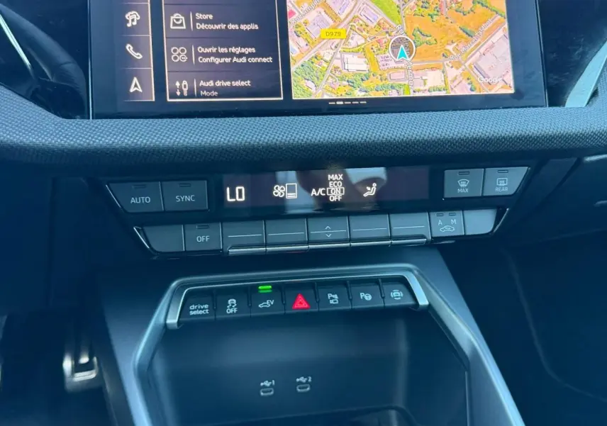 Vue rapprochée de la console centrale de l'Audi A3 Sportback 2025 avec commandes climatisation et écran GPS.