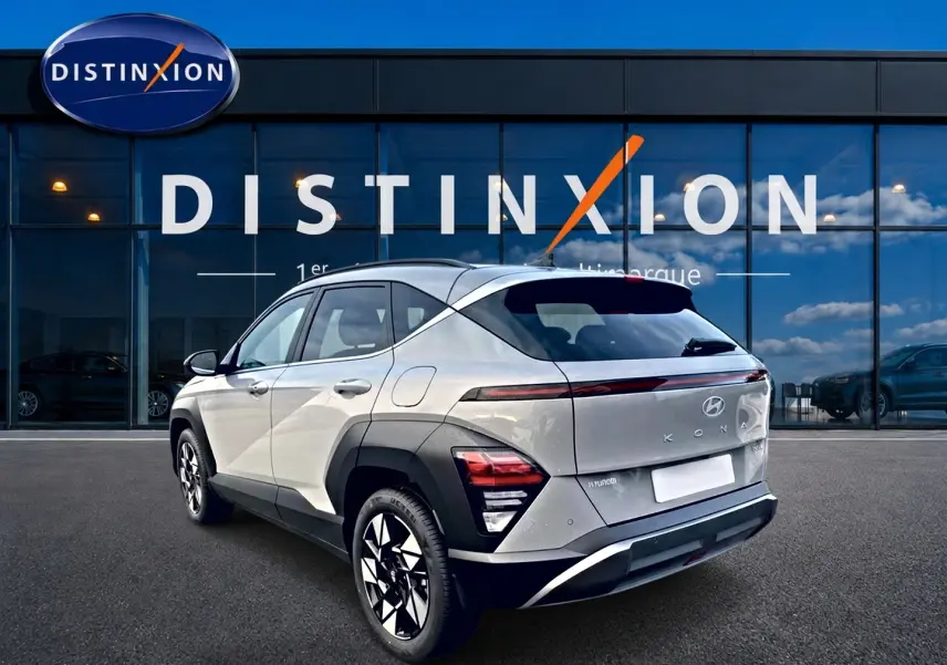 Vue 3/4 arrière droite d'un Hyundai Kona gris 2025 avec feux arrière LED et jantes alliage noires et argent.