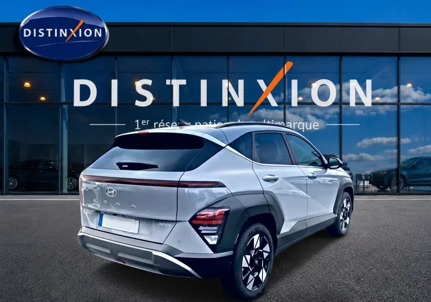 Vue 3/4 arrière droite du Hyundai Kona gris 2025 avec feux LED et jantes alliage 18 pouces devant un showroom Distinxion.