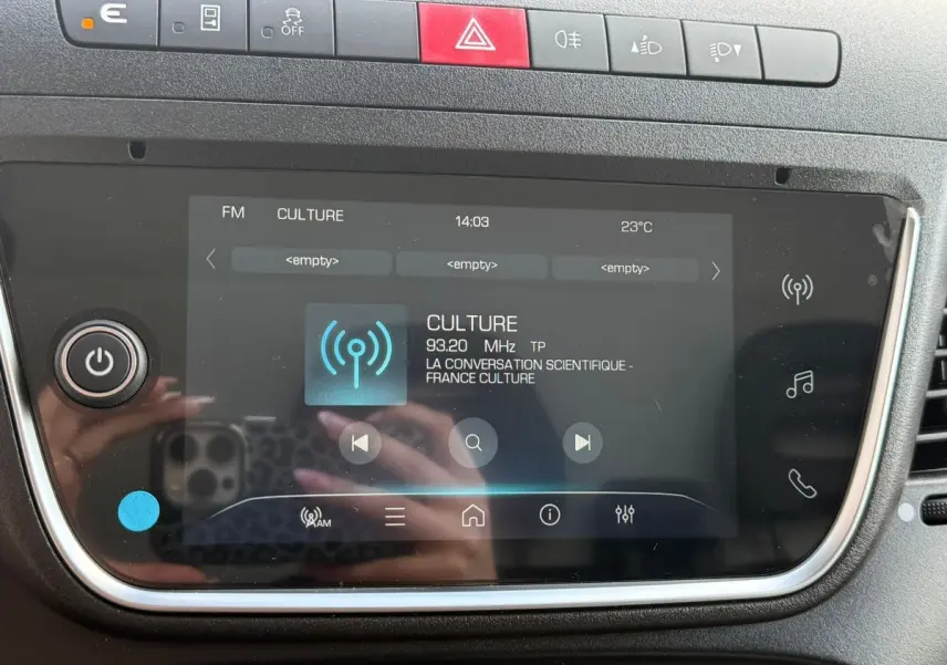 Gros plan sur l’écran tactile central du tableau de bord de l’Iveco Daily blanc, avec commandes et affichage radio FM.