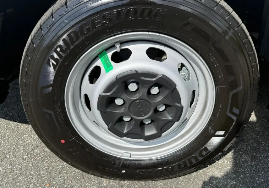 Gros plan sur la roue avant droite d’un Iveco Daily blanc 2026 avec jante acier grise et pneu Bridgestone noir.