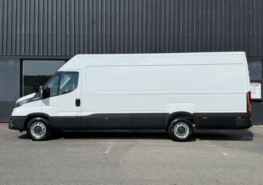 Profil droit d’un utilitaire Iveco Daily blanc, version 35S18 3.0 V16 Himatic 2026, avec bas de caisse noir et jantes acier.