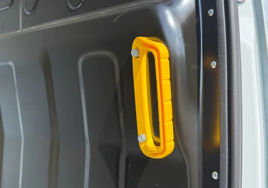 Poignée de maintien jaune en gros plan à l'intérieur d'un fourgon blanc Iveco Daily 35S18 2026.