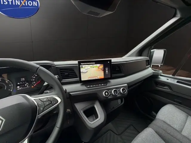 Vue intérieure du tableau de bord du Renault Master 2025 gris urbain, avec écran central affichant la caméra de recul.