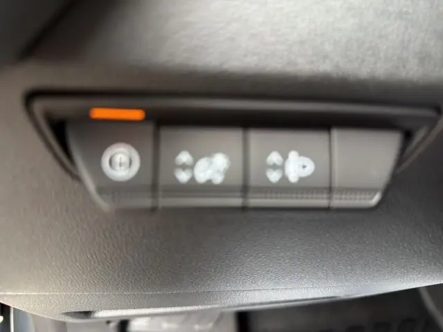 Gros plan sur les commandes de réglage des rétroviseurs et verrouillage centralisé du Renault Master gris urbain 2025.