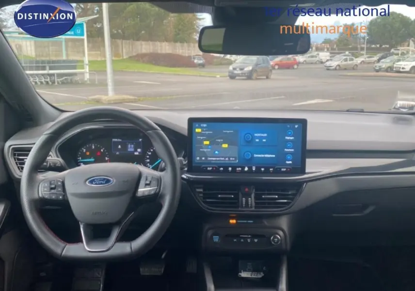 Vue intérieure avant du tableau de bord gris foncé de la Ford Focus 2024 avec écran tactile et volant multifonction.