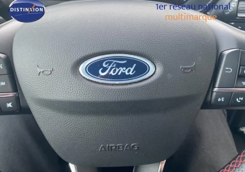 Gros plan sur le volant noir de la Ford Focus 2024, avec logo Ford central et commandes intégrées.