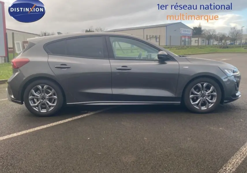 Ford Focus gris foncé vue de profil côté gauche, avec jantes alliage 17 pouces et vitres surteintées.