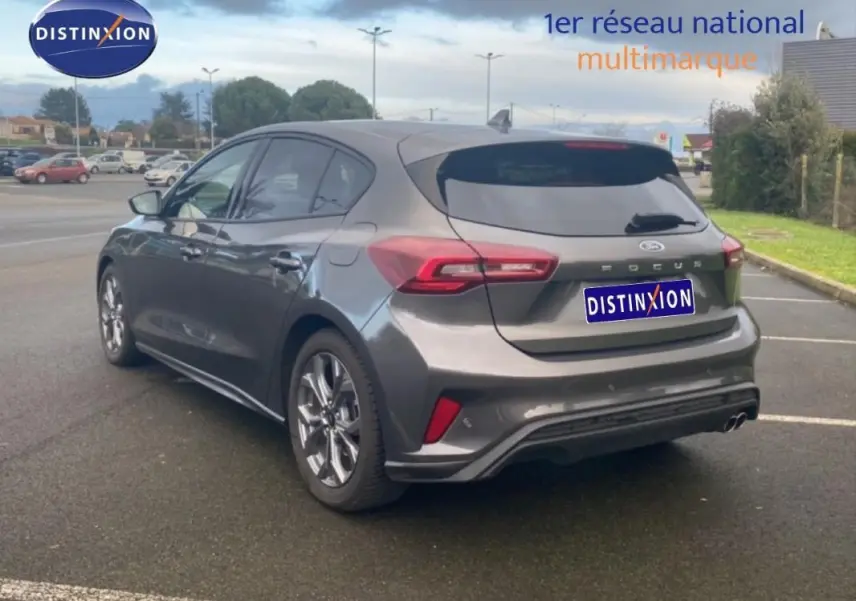 Vue 3/4 arrière droite d'une Ford Focus gris foncé 2024 avec jantes alliage 17 pouces et vitres surteintées.