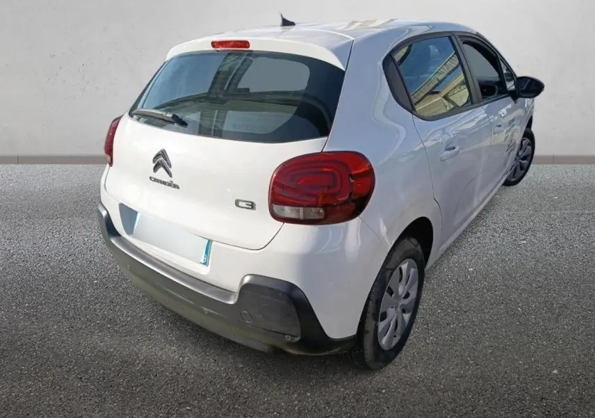 Vue 3/4 arrière droite d'une Citroën C3 blanche de 2021 avec feux arrière arrondis et pare-chocs noir.