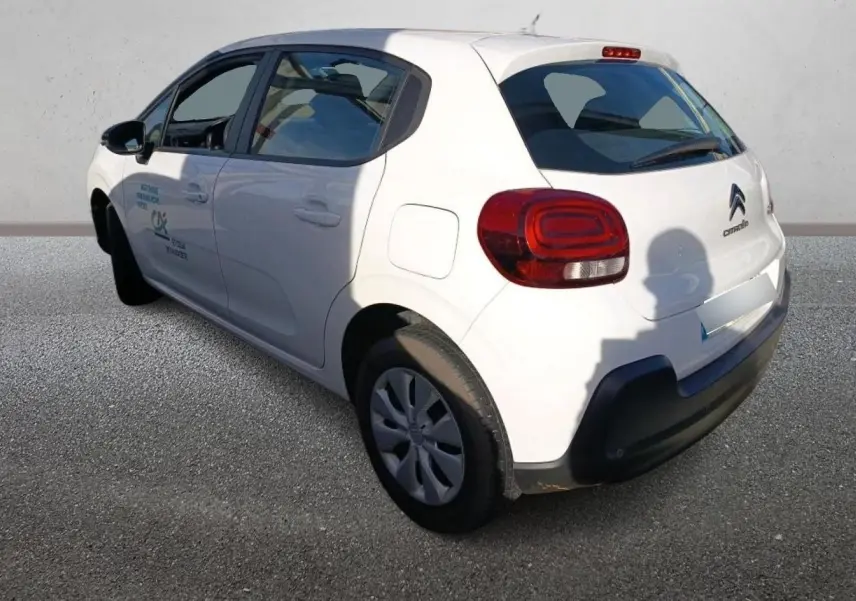 Vue 3/4 arrière gauche d'une Citroën C3 blanche 2021 avec logo et feux arrière rouges bien visibles.