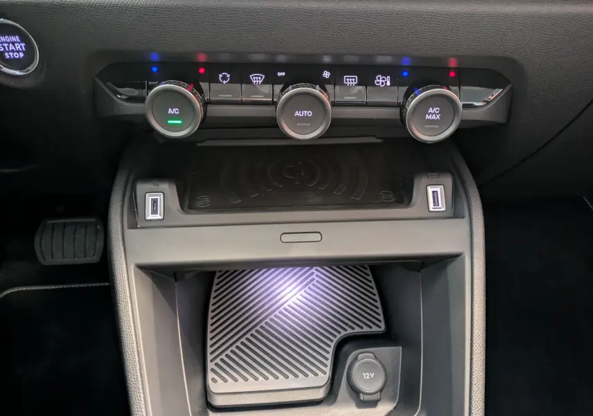 Vue rapprochée de la console centrale noire avec commandes climatisation et chargeur sans fil du Citroën C4 Bleu Eclipse.