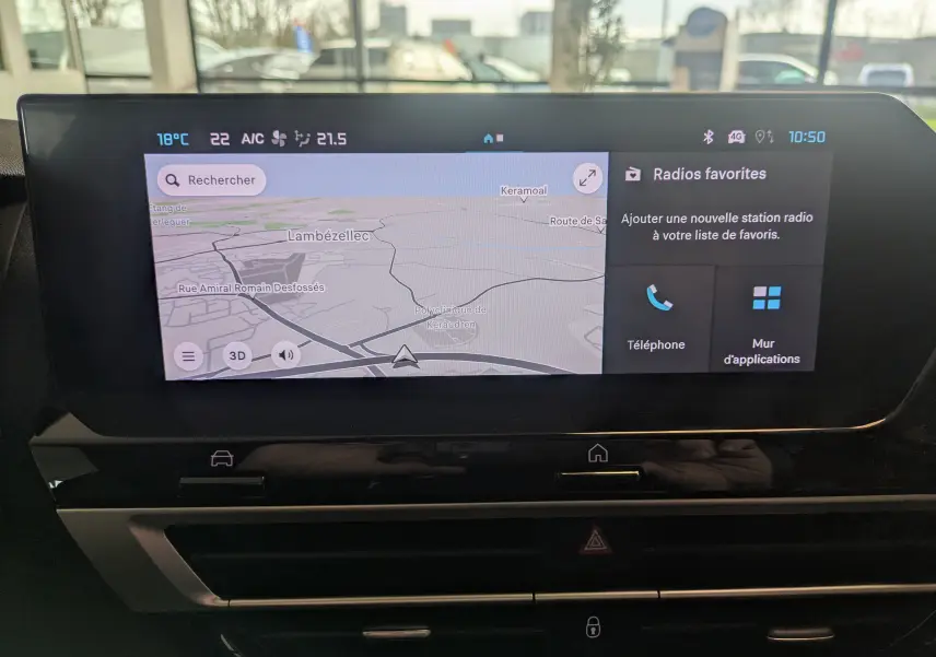 Écran tactile central du tableau de bord de la Citroën C4 Hybride 2025 affichant la navigation et les radios favorites.