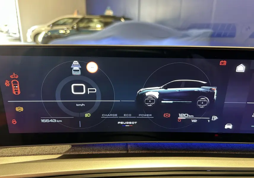 Affichage numérique du tableau de bord du Peugeot 3008 gris Artense, montrant la vitesse et l'autonomie restante.