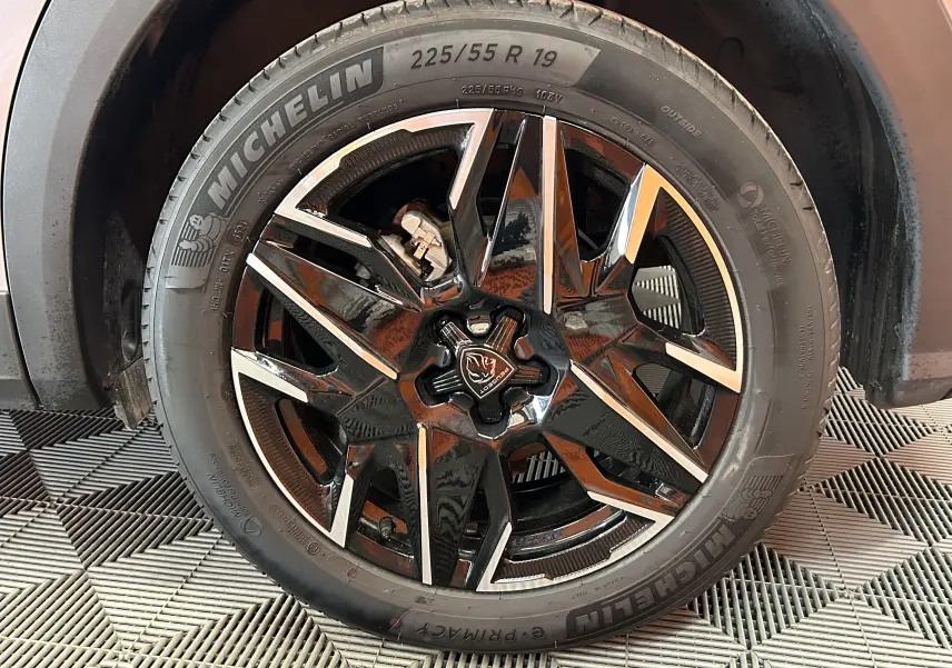 Gros plan sur la jante avant droite noire et argentée du Peugeot 3008 gris Artense, équipée de pneus Michelin.