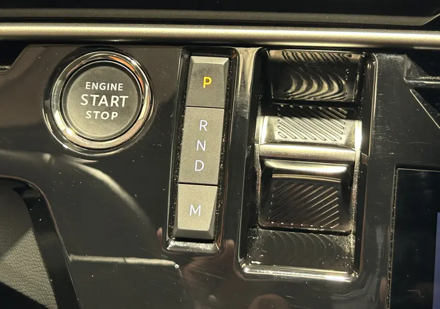 Gros plan sur le bouton Start/Stop et la commande de boîte automatique du Peugeot 3008 gris Artense, intérieur moderne noir brillant.