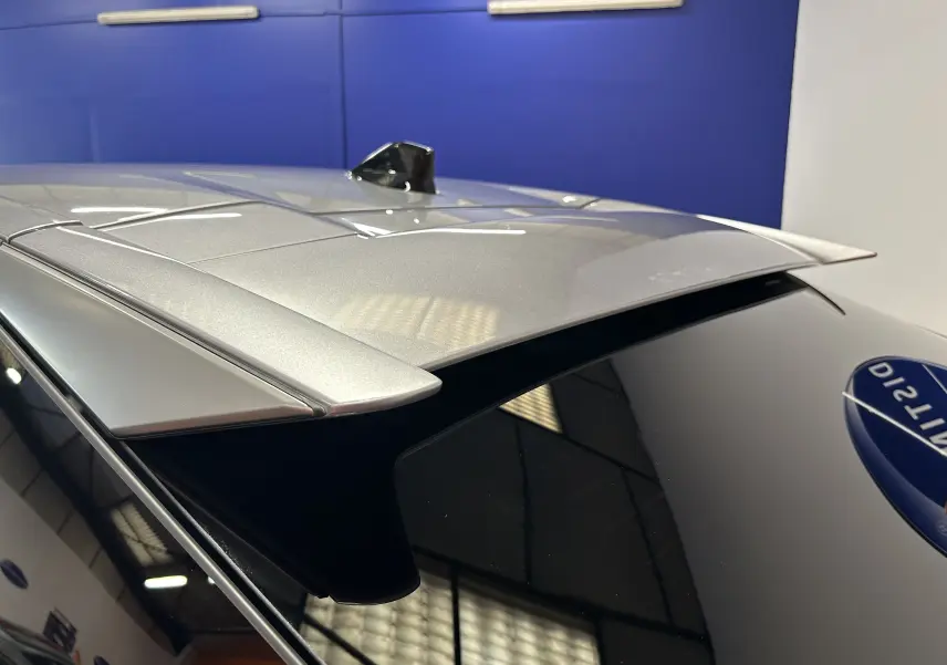 Détail du toit gris Artense du Peugeot 3008 III Hybrid avec antenne requin et becquet arrière, vue en plongée.