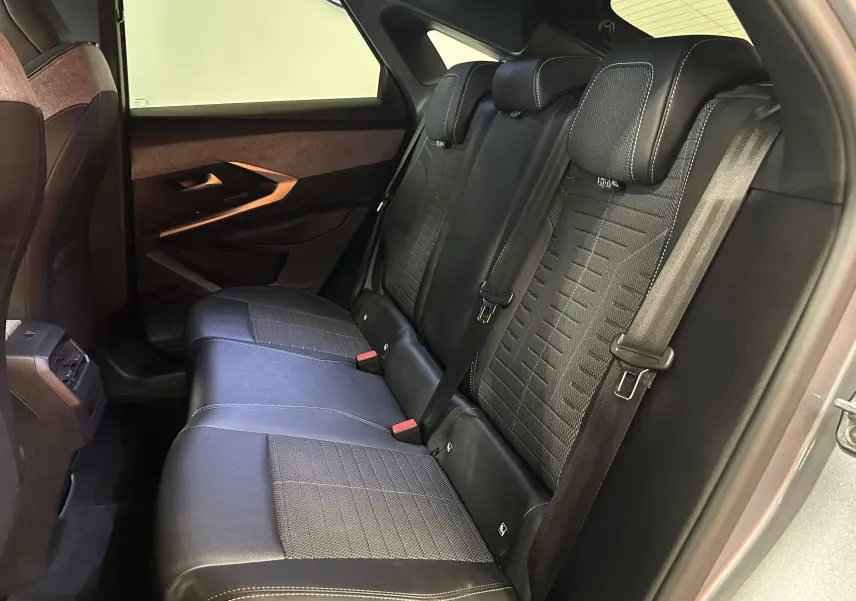 Vue intérieure côté droit des sièges arrière en cuir noir avec surpiqûres blanches du Peugeot 3008 gris Artense 2024.