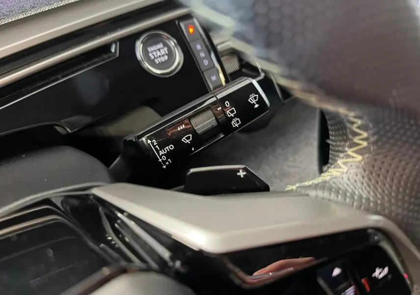 Gros plan intérieur sur la commande d’essuie-glace et bouton start du Peugeot 5008 Hybrid 145 e-DCS6 GT 2025.
