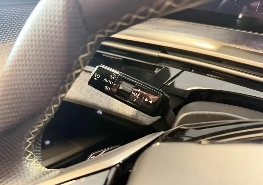 Gros plan sur la commande des feux à gauche du volant du Peugeot 5008 Hybrid 145 e-DCS6 GT 2025.