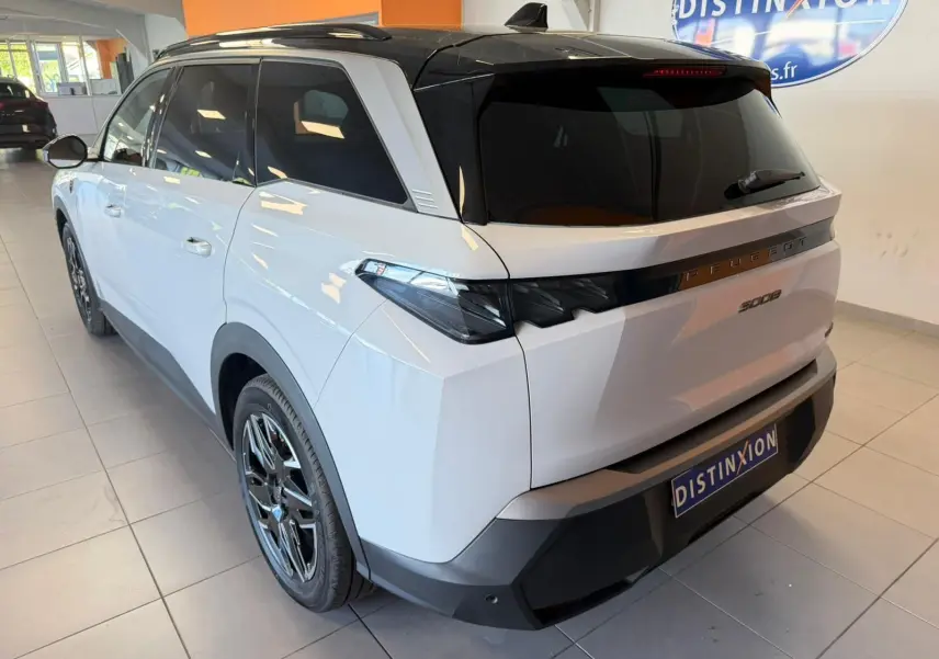 Peugeot 5008 Hybrid blanc Okenite avec toit noir, vue 3/4 arrière droit, jantes alliage 19 pouces visibles.