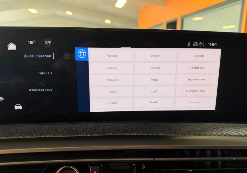 Écran tactile HD 21’’ du Peugeot 5008 Hybrid GT 2025 affichant le menu multilingue, intérieur tissu gris.