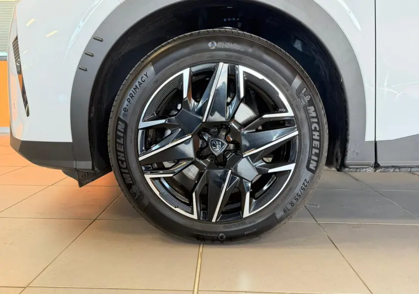 Gros plan sur la jante alliage 19’’ noire et chromée du Peugeot 5008 Hybrid 145 blanc Okenite, côté arrière droit.