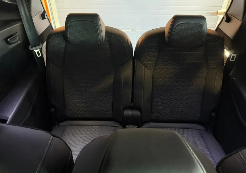 Vue arrière intérieure montrant les deux sièges arrière noirs du Peugeot 5008 Hybrid 145 e-DCS6 GT 2025.