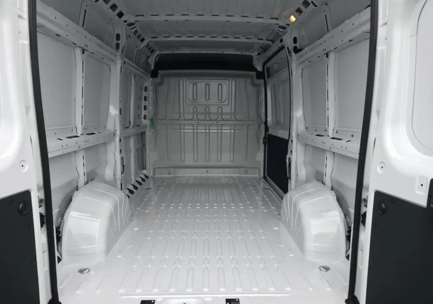 Vue intérieure arrière du fourgon Peugeot Boxer blanc, montrant l'espace de chargement tôlé vide et lumineux.