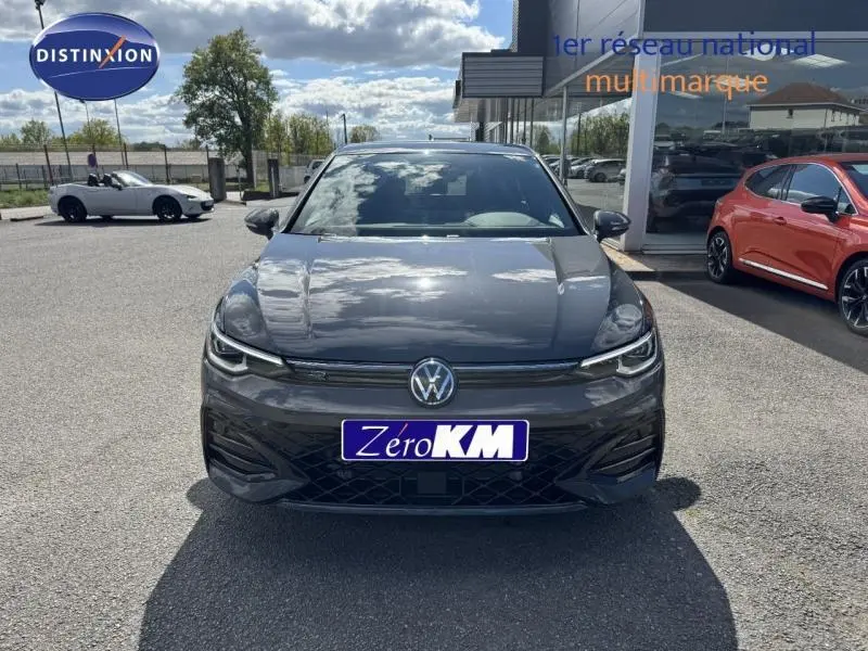 Vue avant d'une Volkswagen Golf 1.5 eTSI R-Line gris lunaire avec calandre noire et phares LED allumés.