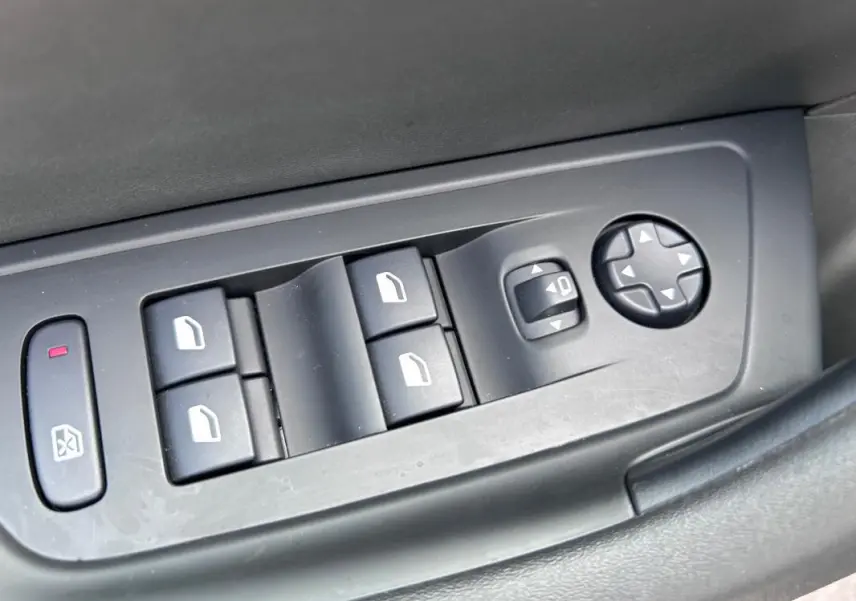 Panneau de commandes des vitres et réglages des rétroviseurs côté conducteur d'une Peugeot 508 Hybrid noire 2024.