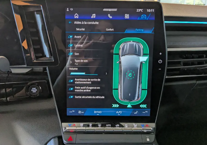 Écran tactile central du Renault Espace VI noir étoile montrant l’aide au stationnement avec vue top-down du véhicule.