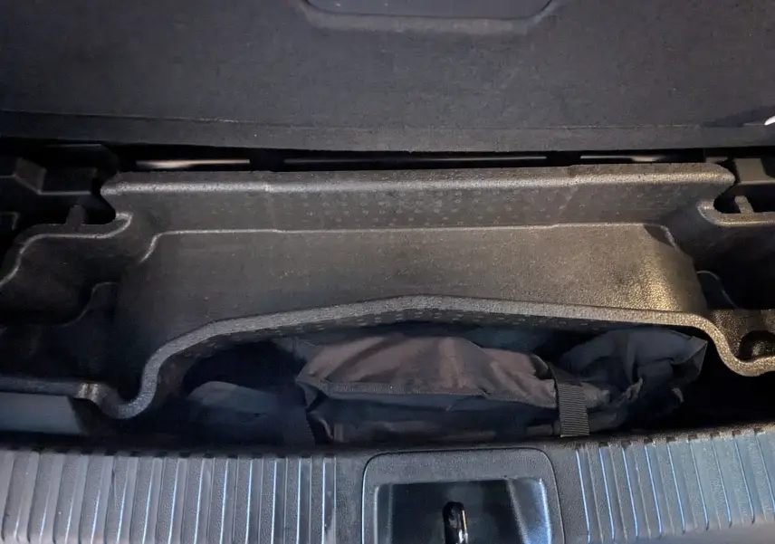 Coffre ouvert du Renault Espace VI noir Étoile, montrant le rangement sous plancher avec sac de secours.
