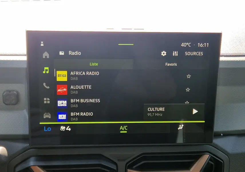 Écran tactile central du Dacia Duster 1.8 Hybrid 155 Extreme affichant la liste des radios DAB, intérieur noir.