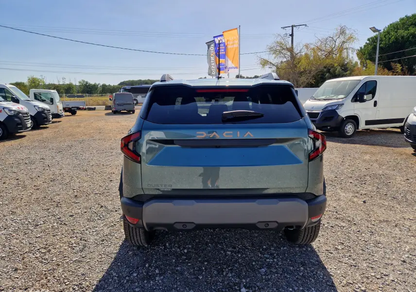Vue arrière d'un Dacia Duster 1.8 Hybrid 155 Vert Cèdre, avec logo DACIA en relief et feux arrière anguleux.